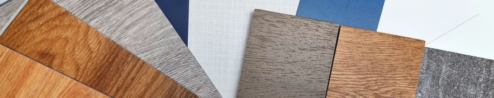 A collection of wood flooring samples showcasing different colors, textures, and finishes arranged on a display board.
