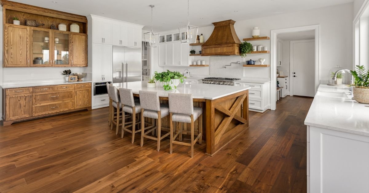 A modern kitchen featuring wooden floors and white cabinets, creating a bright and inviting atmosphere.