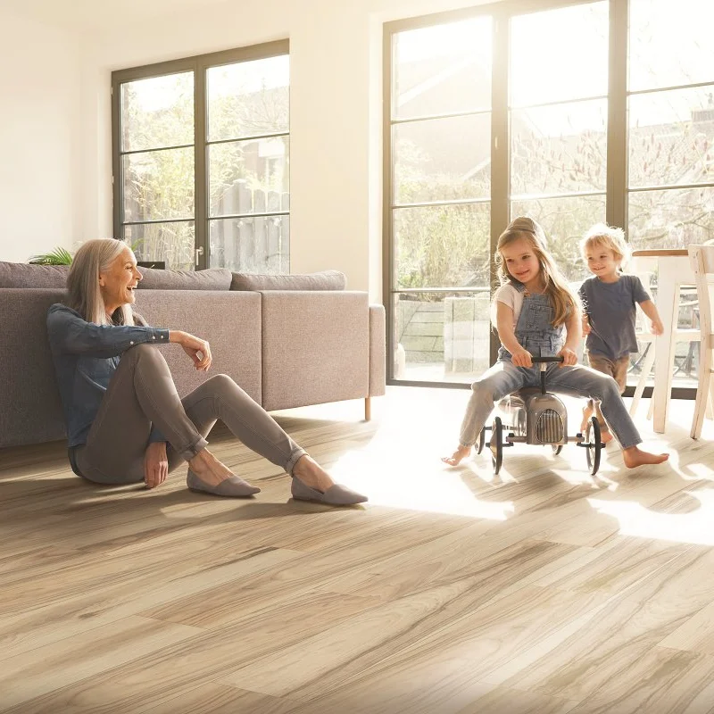 Grandmother sitting on laminate floors playing with her grandkids