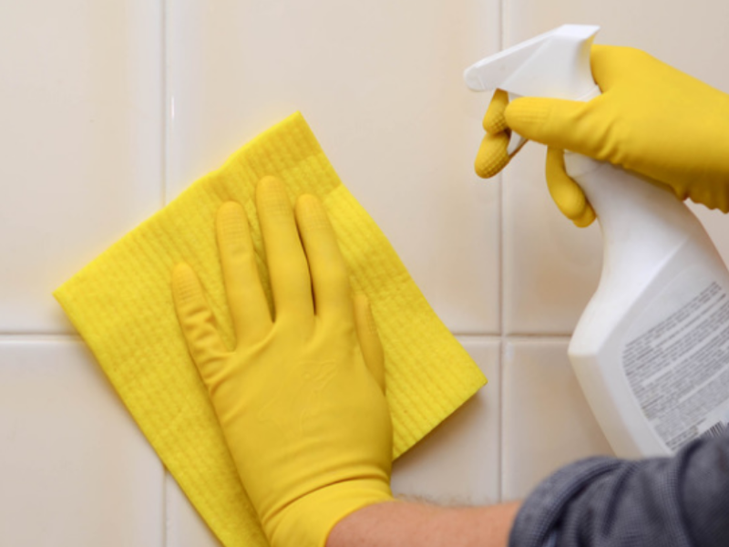 Person with gloves cleaning tile