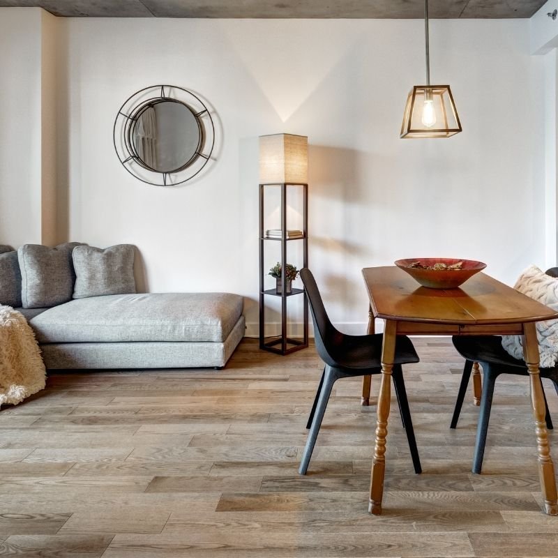 A cozy living room featuring a wooden floor and a central table, creating a warm and inviting atmosphere.