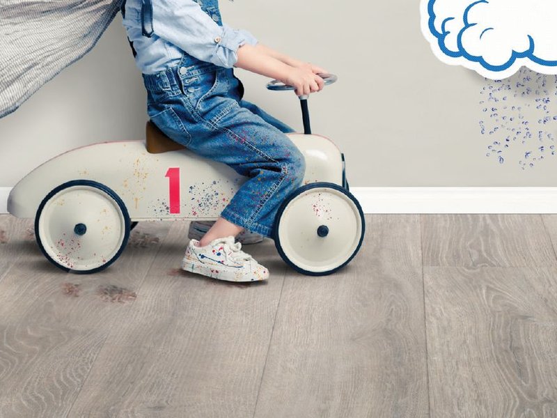 Toddler playing on Revwood resistance hardwood flooring.