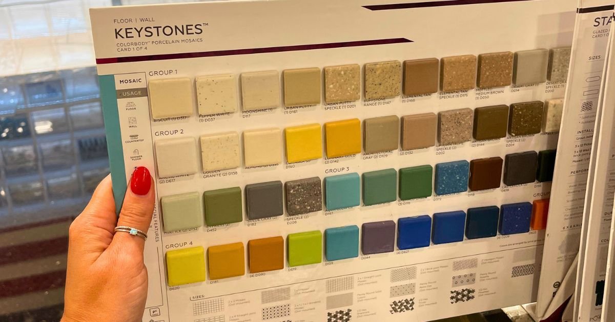 A hand holds a brochure showcasing an array of colored tile options.