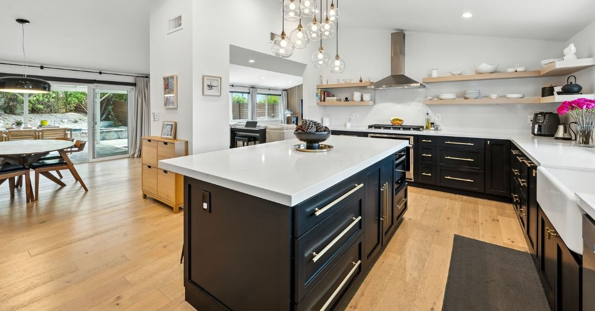 A modern kitchen featuring sleek black cabinets paired with bright white countertops.