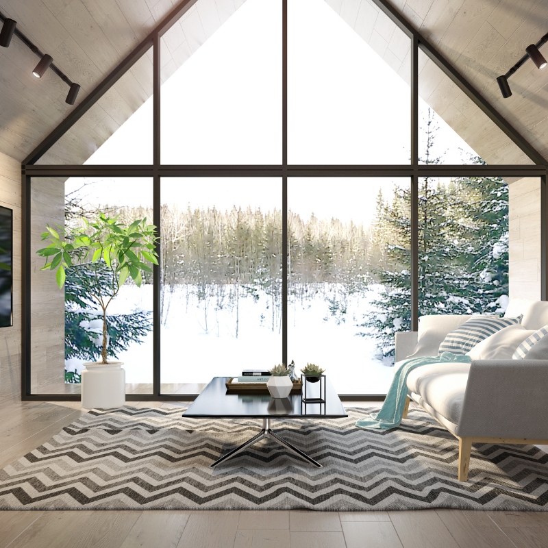 A spacious living room featuring a large window and a comfortable couch, inviting natural light into the space.